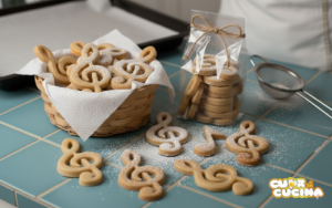 Biscotti a forma di chiave di violino con zucchero a velo in un cestino e in bustine regalo trasparenti.